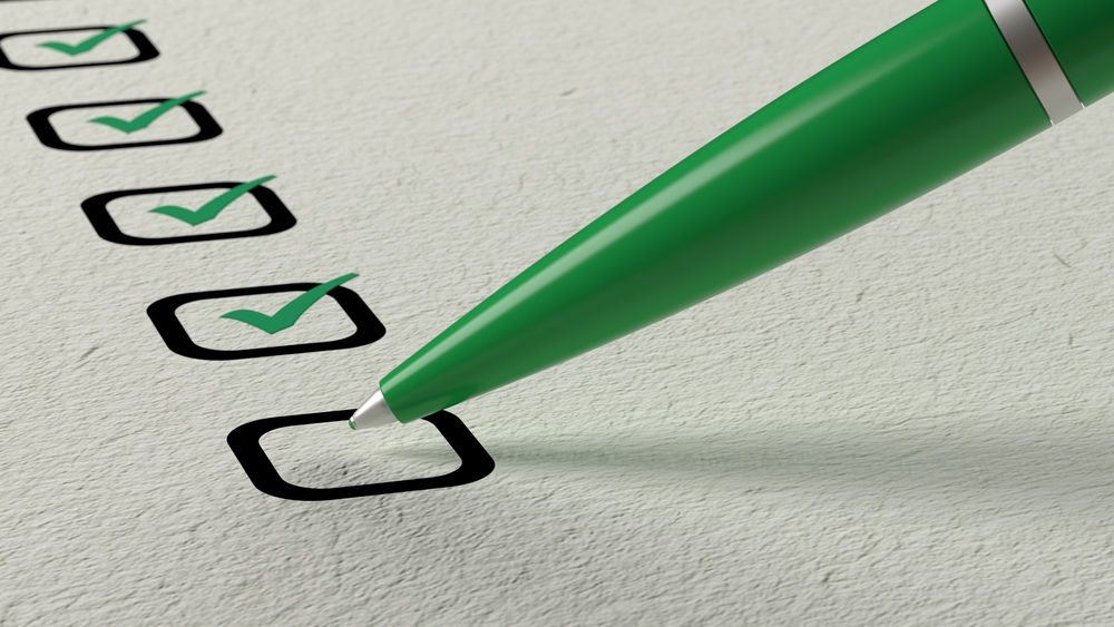 Marking checks on a moving checklist with a pen.