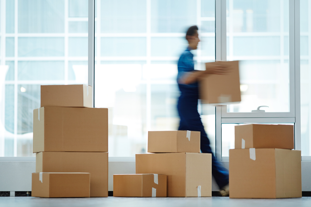 mover carrying a moving box from a pile of boxes for commercial moving.