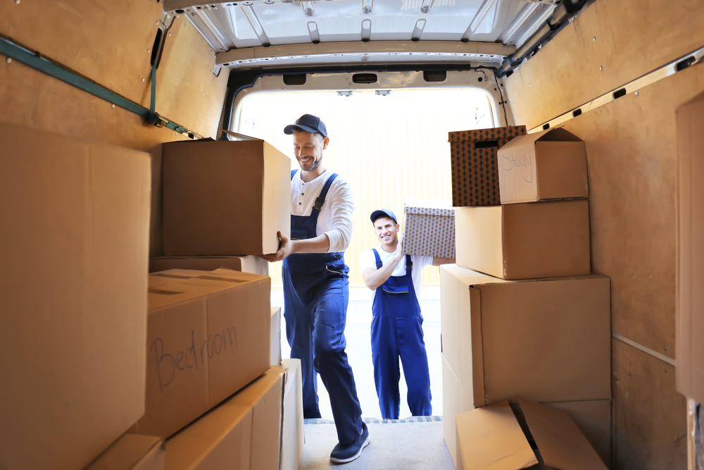 Two movers loading a moving van with boxes.